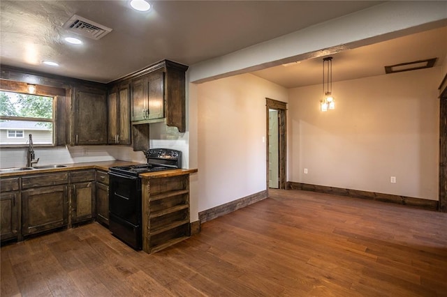 103 E Ash St, Carnegie, OK 73015 - kitchen featuring black electric range, dark wood-style flooring, dark brown cabinetry, and recessed lighting