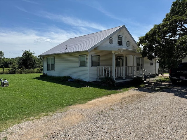 12237 N 359th Rd, Seminole, OK 74868 - view of front of home with covered porch, a front lawn, a metal roof, and gravel driveway