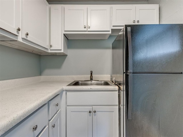 506 SW 24th St, Oklahoma City, OK 73109 - kitchen with freestanding refrigerator, white cabinetry, and light countertops