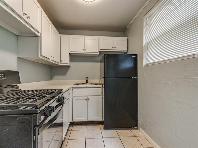 506 SW 24th St, Oklahoma City, OK 73109 - kitchen with black appliances, white cabinets, light tile patterned floors, and light countertops