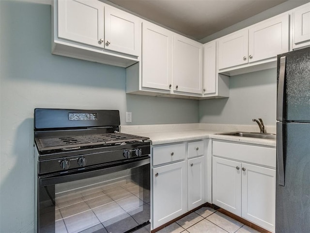 506 SW 24th St, Oklahoma City, OK 73109 - kitchen with black appliances, white cabinets, light tile patterned flooring, and light countertops