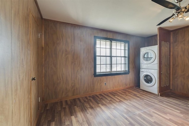 2527 NW 62nd St Unit 214, Oklahoma City, OK 73112 - laundry room featuring stacked washer / drying machine, wood finished floors, ceiling fan, and wooden walls