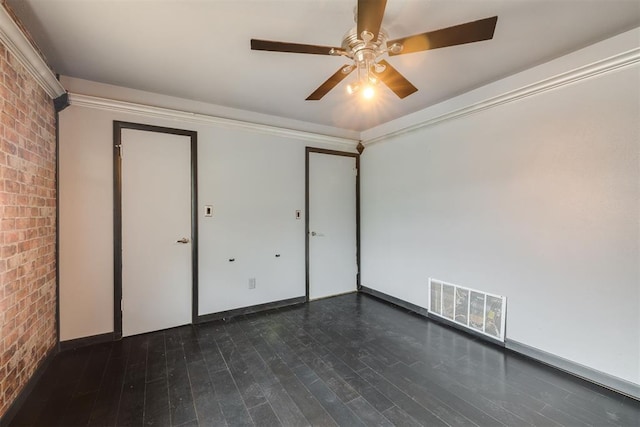 2527 NW 62nd St Unit 214, Oklahoma City, OK 73112 - unfurnished bedroom with brick wall, dark wood-type flooring, and ceiling fan