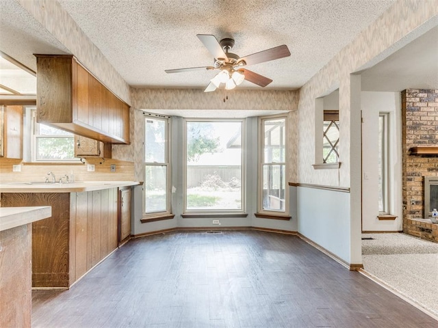 804 Royal Ln, Yukon, OK 73099 - kitchen featuring a textured ceiling, light countertops, ceiling fan, wood finished floors, and brown cabinetry