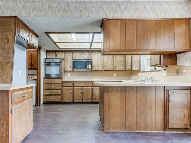 804 Royal Ln, Yukon, OK 73099 - kitchen featuring stainless steel appliances, brown cabinets, light countertops, and wood finished floors