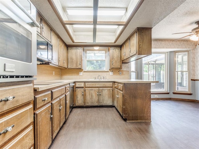 804 Royal Ln, Yukon, OK 73099 - kitchen with a peninsula, light wood finished floors, light countertops, stainless steel appliances, and ceiling fan