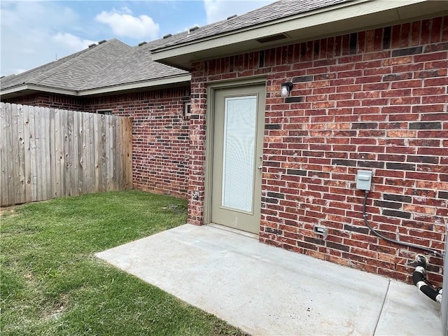 1010 SW 91st St, Oklahoma City, OK 73139 - property entrance featuring a shingled roof, a patio area, and brick siding