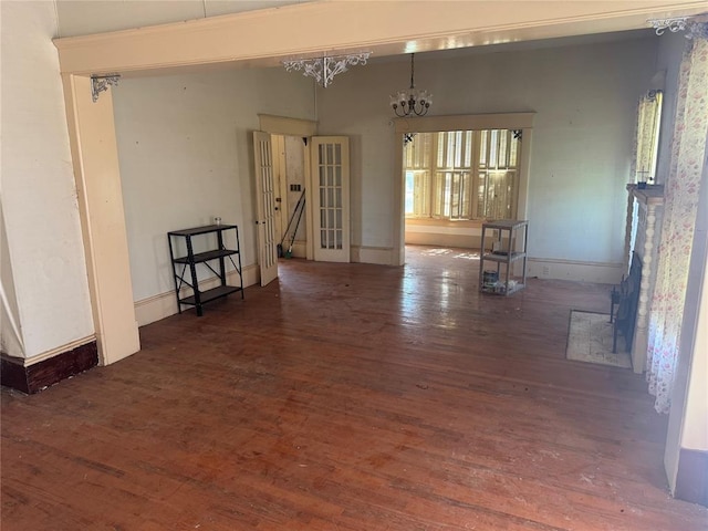 empty room featuring wood finished floors and a chandelier
