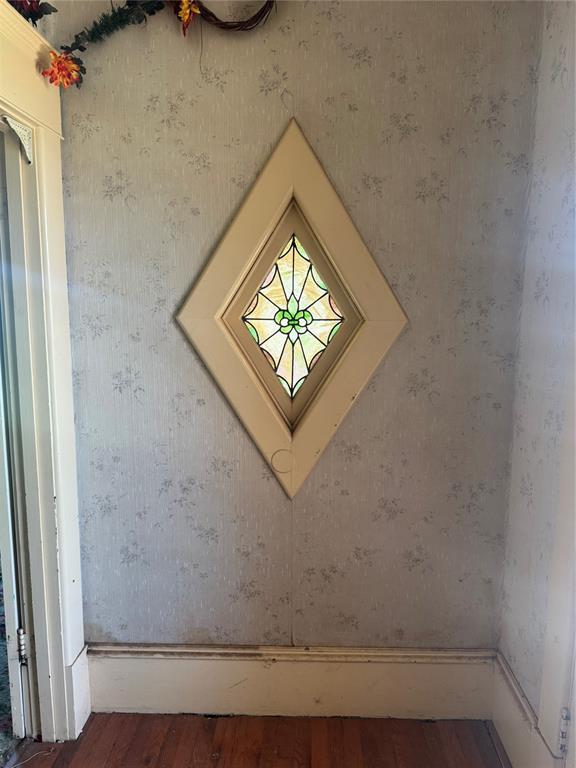detailed view of wood finished floors and wallpapered walls