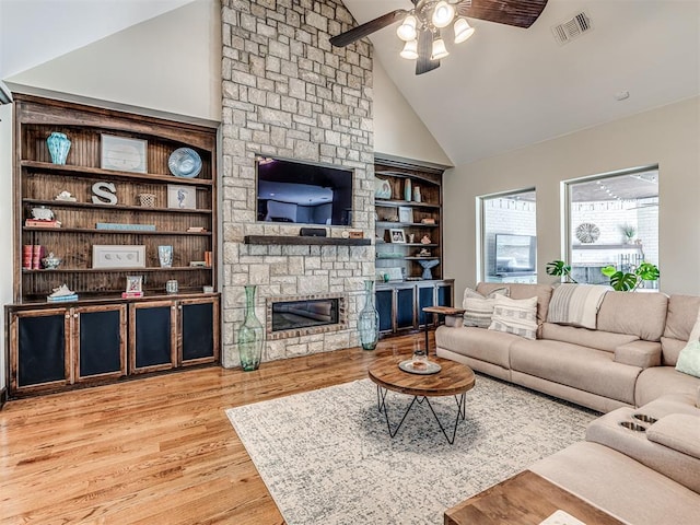 4311 Moorgate Dr, Norman, OK 73072 - living room featuring a ceiling fan, a stone fireplace, wood finished floors, and high vaulted ceiling