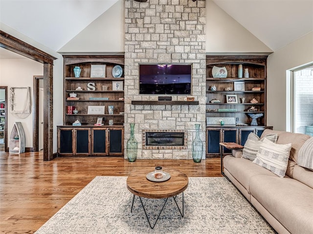 4311 Moorgate Dr, Norman, OK 73072 - living area featuring vaulted ceiling, wood finished floors, and a stone fireplace