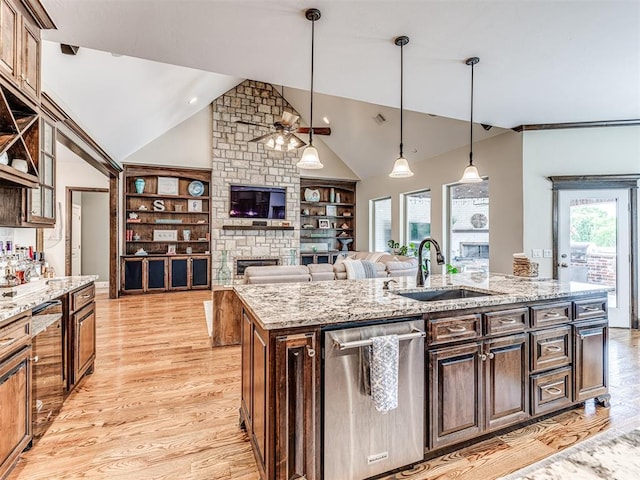 4311 Moorgate Dr, Norman, OK 73072 - kitchen with dishwasher, vaulted ceiling, light wood-style flooring, ceiling fan, and a fireplace