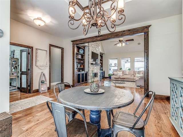 4311 Moorgate Dr, Norman, OK 73072 - dining space with a fireplace, light wood-style floors, ceiling fan, and a chandelier