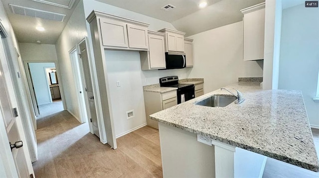 1614 SW C Ave, Lawton, OK 73501 - kitchen with appliances with stainless steel finishes, a peninsula, light stone counters, light carpet, and vaulted ceiling