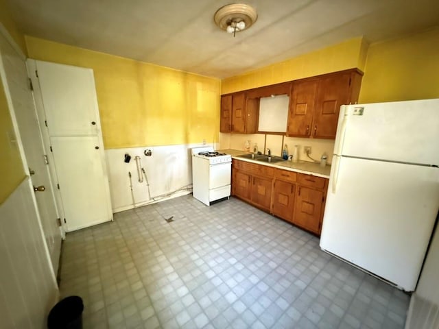 8821 NE 50th St, Spencer, OK 73084 - kitchen with white appliances, light countertops, dark floors, and brown cabinets