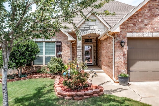 3309 Austrian Pine Ln, Yukon, OK 73099 - view of exterior entry with a garage, brick siding, a shingled roof, and a yard