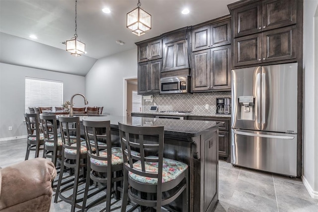 3309 Austrian Pine Ln, Yukon, OK 73099 - kitchen with appliances with stainless steel finishes, an island with sink, backsplash, a breakfast bar area, and dark brown cabinetry