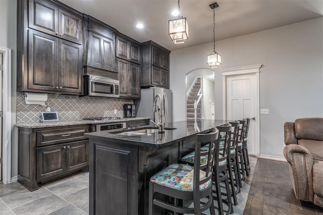 3309 Austrian Pine Ln, Yukon, OK 73099 - kitchen with stainless steel appliances, backsplash, a kitchen bar, and dark stone counters