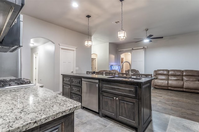 3309 Austrian Pine Ln, Yukon, OK 73099 - kitchen featuring stainless steel appliances, arched walkways, ceiling fan, open floor plan, and a barn door