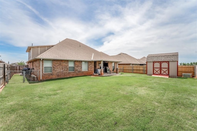 3309 Austrian Pine Ln, Yukon, OK 73099 - rear view of house with a fenced backyard, a storage unit, a patio, brick siding, and roof with shingles