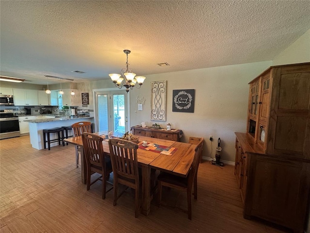 35352 Ew 1260th Rd, Seminole, OK 74868 - dining area with a chandelier, light wood-type flooring, and a textured ceiling