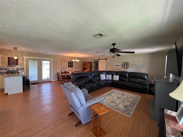 35352 Ew 1260th Rd, Seminole, OK 74868 - living room with wood finished floors, a ceiling fan, a textured ceiling, and a chandelier