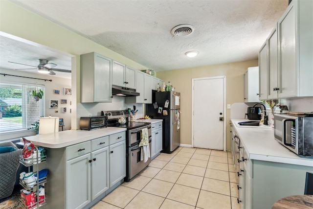 709 W Hughbert St, Norman, OK 73069 - kitchen with appliances with stainless steel finishes, under cabinet range hood, light countertops, light tile patterned floors, and ceiling fan