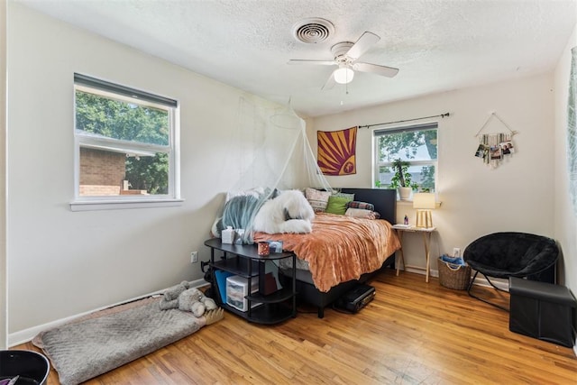 709 W Hughbert St, Norman, OK 73069 - bedroom featuring wood finished floors, a textured ceiling, and a ceiling fan