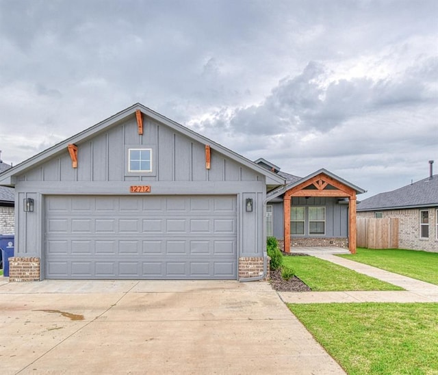 12712 NW 4th St, Yukon, OK 73099 - view of front of house with board and batten siding, a front yard, brick siding, and concrete driveway
