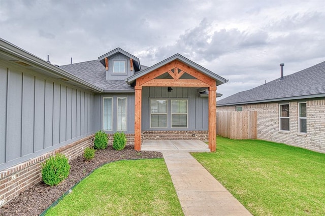 12712 NW 4th St, Yukon, OK 73099 - doorway to property featuring board and batten siding, roof with shingles, and brick siding