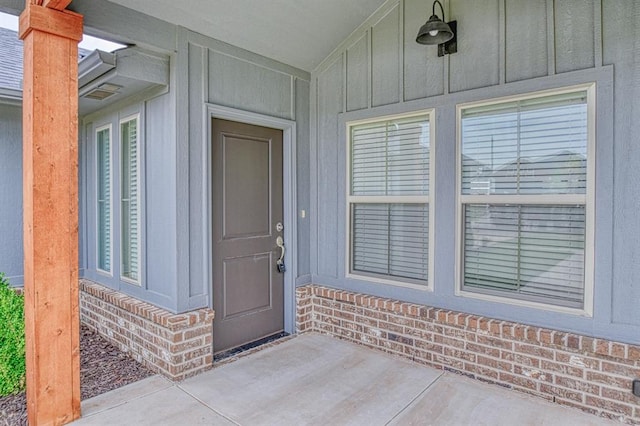 12712 NW 4th St, Yukon, OK 73099 - view of exterior entry featuring board and batten siding and brick siding