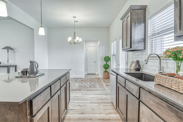 12712 NW 4th St, Yukon, OK 73099 - kitchen featuring light wood-style flooring, stainless steel dishwasher, tasteful backsplash, a chandelier, and decorative light fixtures