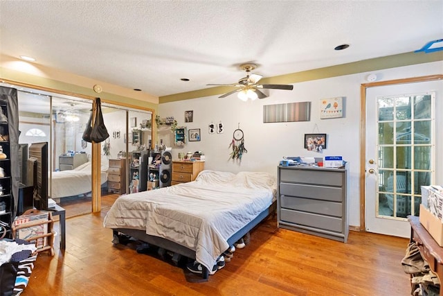 12725 Silver Ln, Oklahoma City, OK 73120 - bedroom with multiple closets, light wood-style floors, and a textured ceiling