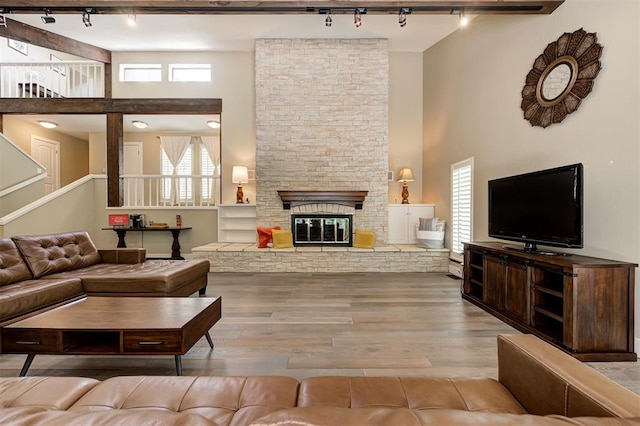 1810 Sandpiper Dr, Edmond, OK 73034 - living area with track lighting, a high ceiling, wood finished floors, a fireplace, and stairway