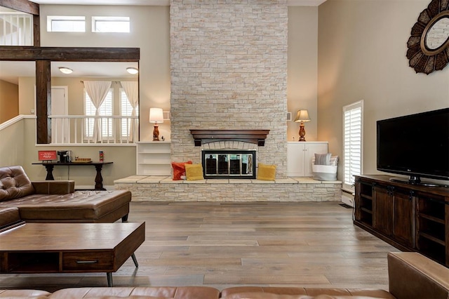 1810 Sandpiper Dr, Edmond, OK 73034 - living room featuring a high ceiling, wood finished floors, plenty of natural light, and a stone fireplace
