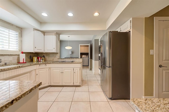 1810 Sandpiper Dr, Edmond, OK 73034 - kitchen with freestanding refrigerator, washer / dryer, white cabinetry, tasteful backsplash, and recessed lighting