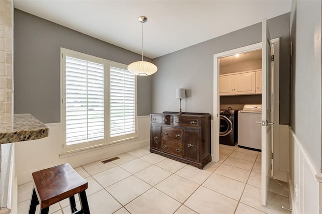 1810 Sandpiper Dr, Edmond, OK 73034 - dining area featuring washing machine and clothes dryer, a wainscoted wall, healthy amount of natural light, and light tile patterned floors