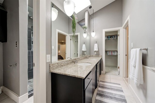 1810 Sandpiper Dr, Edmond, OK 73034 - ensuite bathroom with high vaulted ceiling, a spacious closet, double vanity, and tile patterned floors