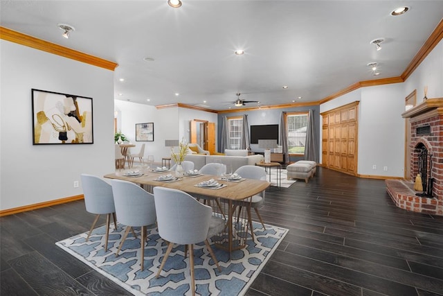 dining space with ornamental molding, a brick fireplace, ceiling fan, wood finished floors, and recessed lighting