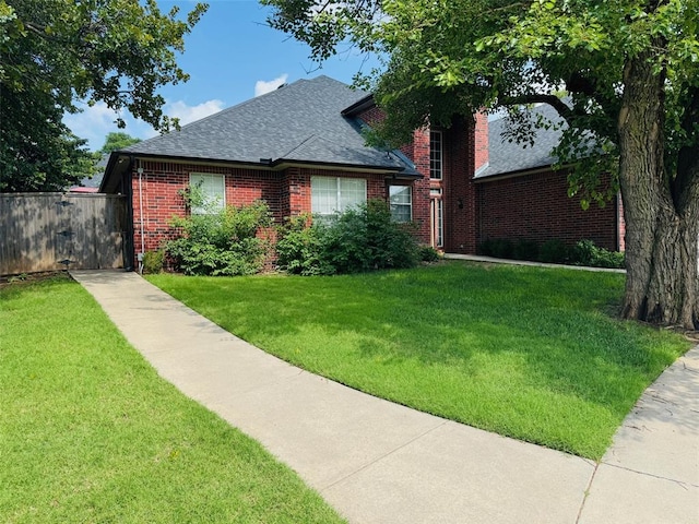 view of front facade with brick siding and a shingled roof