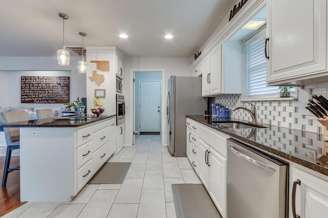 4813 NW 65th St, Oklahoma City, OK 73132 - kitchen with stainless steel appliances, a breakfast bar area, tasteful backsplash, white cabinetry, and dark stone counters
