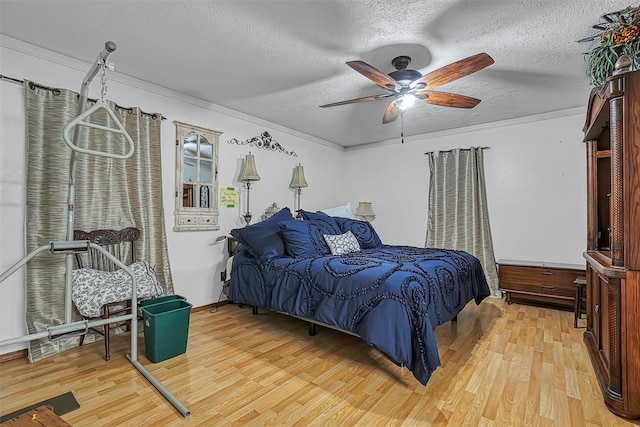 1108 S 13th St, Clinton, OK 73601 - bedroom featuring light wood finished floors, a textured ceiling, ornamental molding, and a ceiling fan