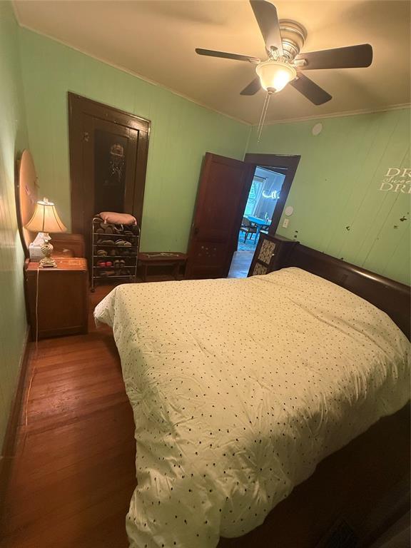 1522 S 9th St, Chickasha, OK 73018 - bedroom with wood finished floors, a ceiling fan, and ornamental molding
