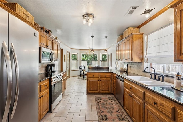 5 Larkens Pl, Shawnee, OK 74801 - kitchen with stainless steel appliances, dark countertops, brown cabinetry, a peninsula, and tasteful backsplash