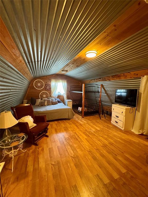 182424 N 4159th Rd, Moyers, OK 74557 - bedroom featuring lofted ceiling, hardwood / wood-style floors, and wood walls