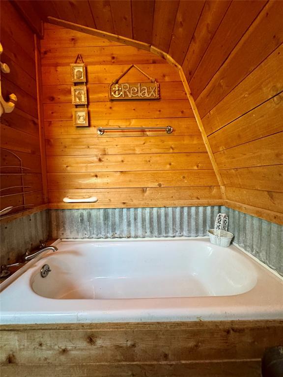 182424 N 4159th Rd, Moyers, OK 74557 - full bathroom featuring wood walls, a bath, wood ceiling, and vaulted ceiling