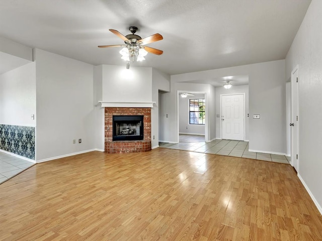 4001 Tori Pl, Yukon, OK 73099 - unfurnished living room featuring a ceiling fan, light wood-style floors, and a fireplace
