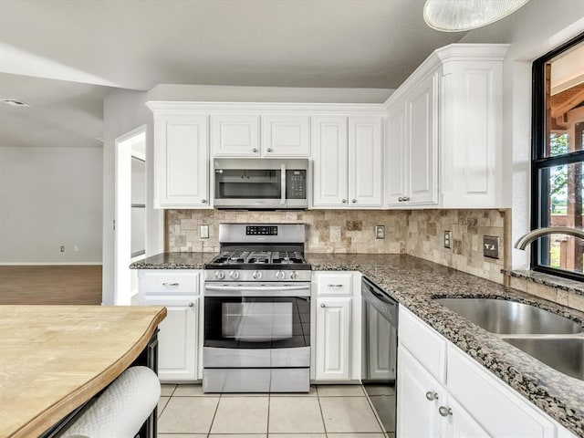 4001 Tori Pl, Yukon, OK 73099 - kitchen featuring stainless steel appliances, white cabinetry, backsplash, and light tile patterned flooring