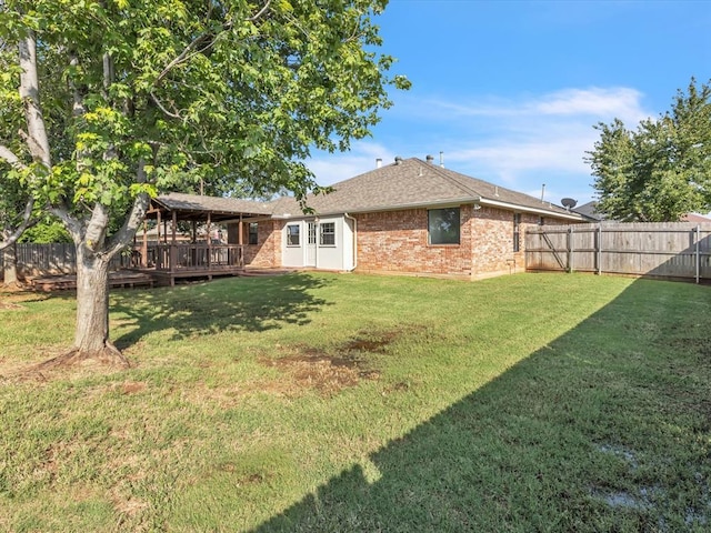 4001 Tori Pl, Yukon, OK 73099 - back of property featuring a wooden deck, a fenced backyard, brick siding, and roof with shingles