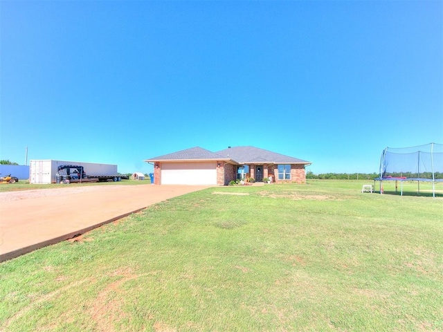 5053 Northridge Run, Cashion, OK 73016 - view of front of home featuring a trampoline, a front yard, concrete driveway, an attached garage, and brick siding